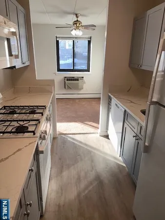 a kitchen with stainless steel appliances a stove a microwave a sink a refrigerator and a stove