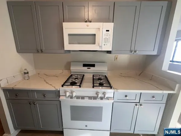 a white stove top oven sitting inside of a kitchen