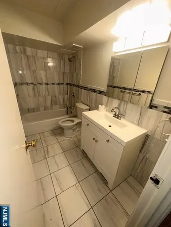a bathroom with a sink a toilet and a mirror
