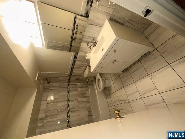 873 Main Street, Unit 2E Hackensack, NJ 07601 - Photo 9 of 23 a bathroom with a sink a toilet and shower