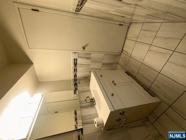 873 Main Street, Unit 2E Hackensack, NJ 07601 - Photo 10 of 23 a bathroom with a sink a toilet and a mirror