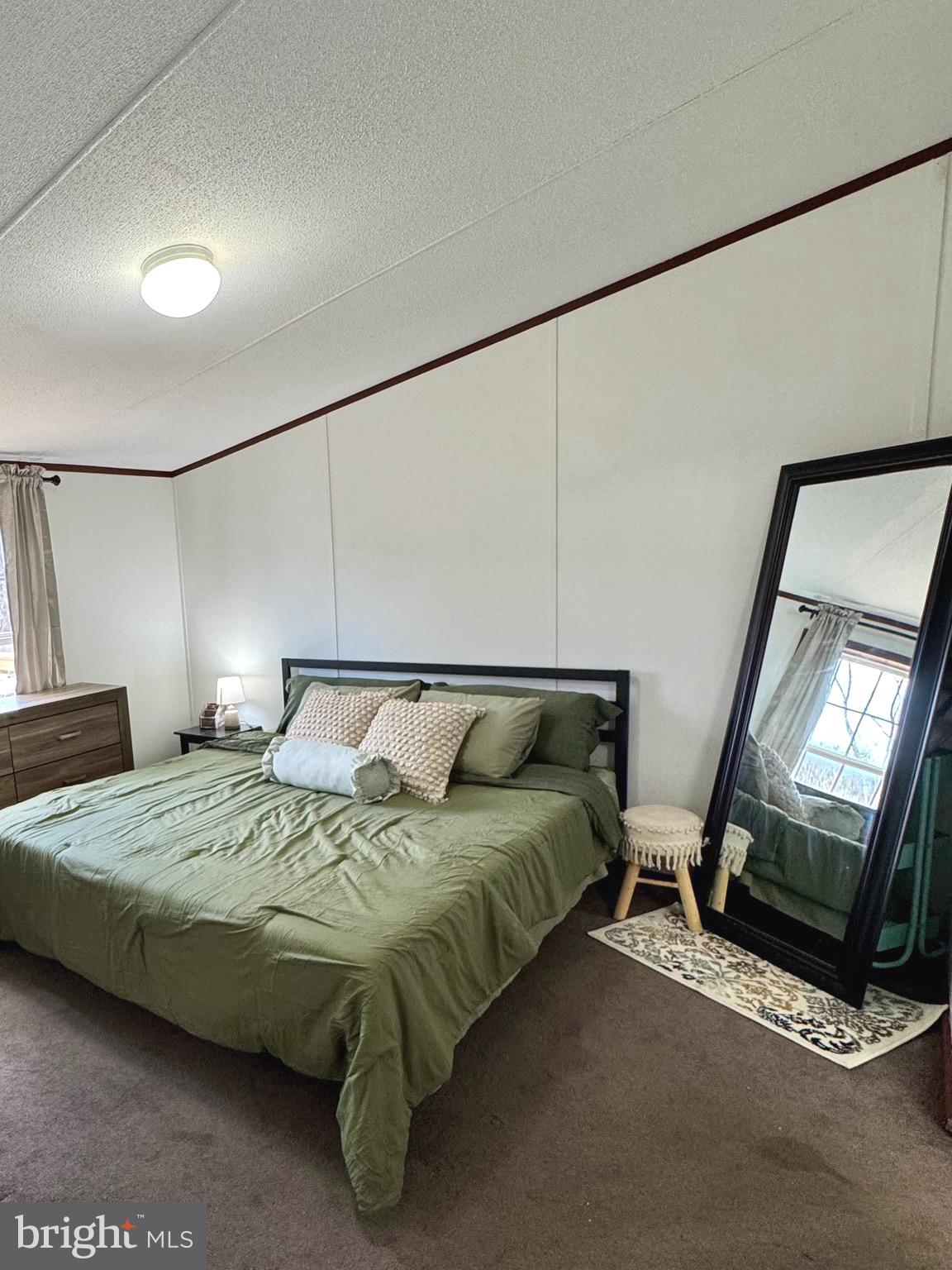 73 Mill Gap Road Brandywine, WV 26802 - Photo 17 of 35 a bedroom with a bed a mirror on dresser and a table