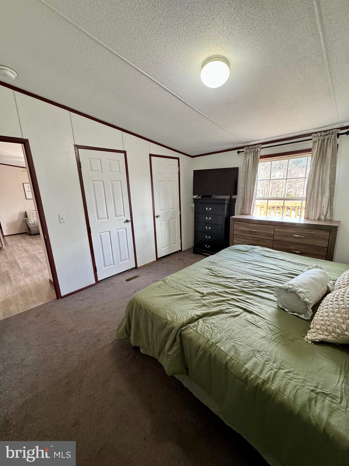 73 Mill Gap Road Brandywine, WV 26802 - Photo 19 of 35 a bedroom with a bed and a flat tv screen on dresser