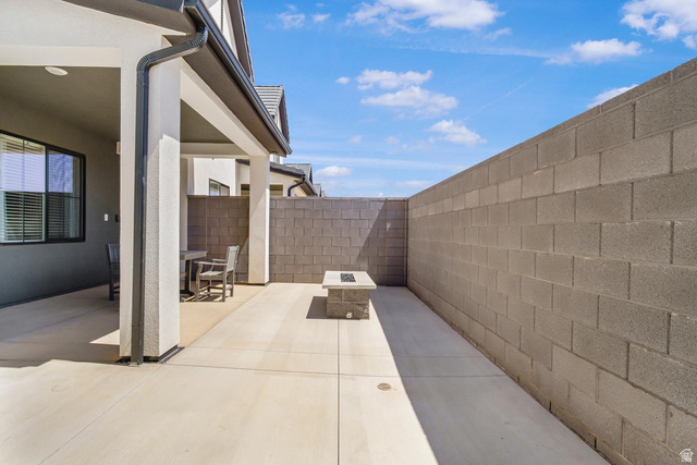 1705 Ripple Rock Drive, Unit 3017 Washington, UT 84780 - Photo 17 of 22 Covered patio with concrete flooring, accented by a built-in fire pit with a light-colored top