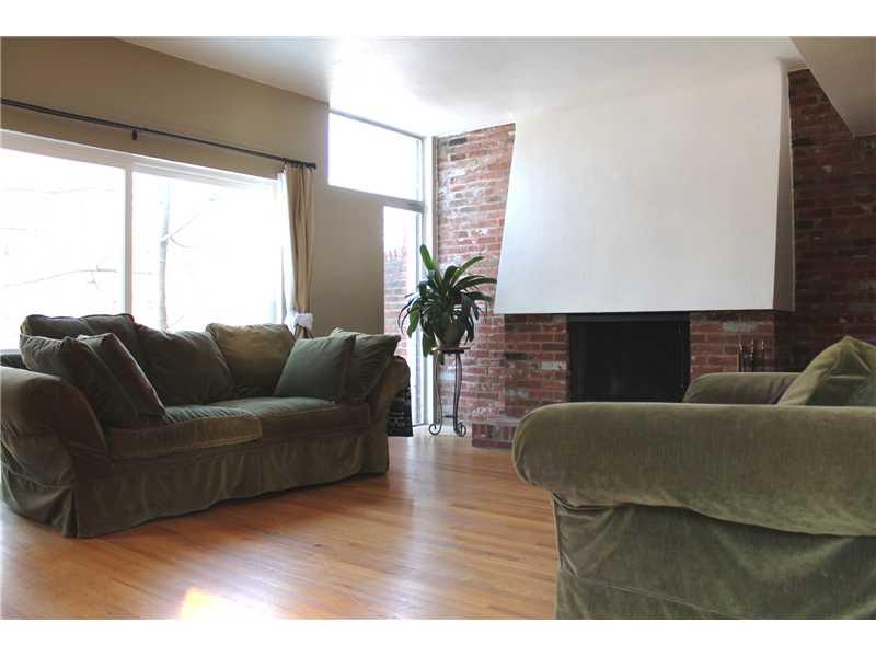 154 Maple Heights Road Pittsburgh, PA 15232 - Photo 4 of 17 Living Room. Tons of windows, hardwood floors, and log burning fireplace. Sliders behind couch lead to a deck.