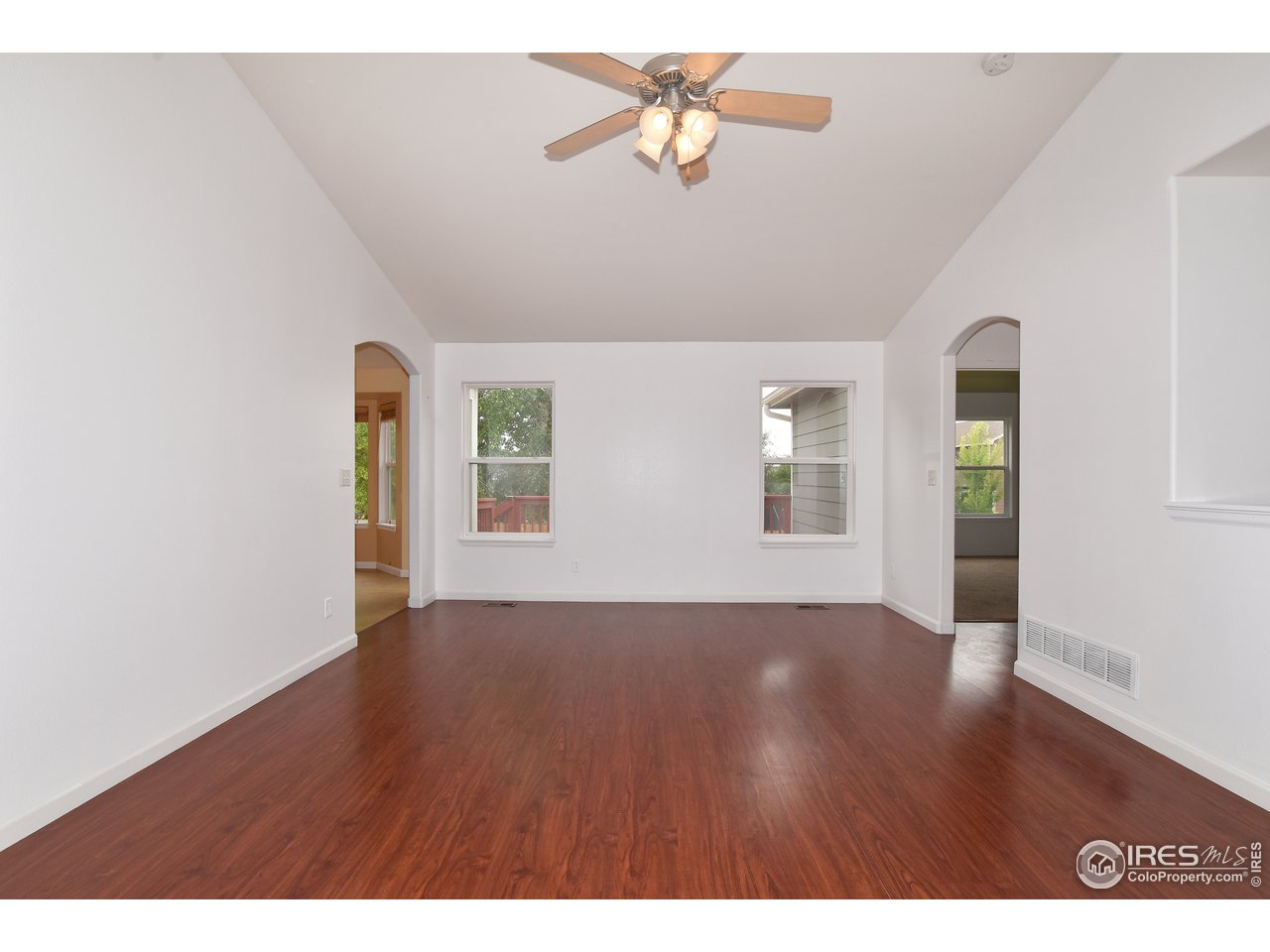924 Cliffrose Way Severance, CO 80550 - Photo 13 of 40 a view of an empty room with window and wooden floor