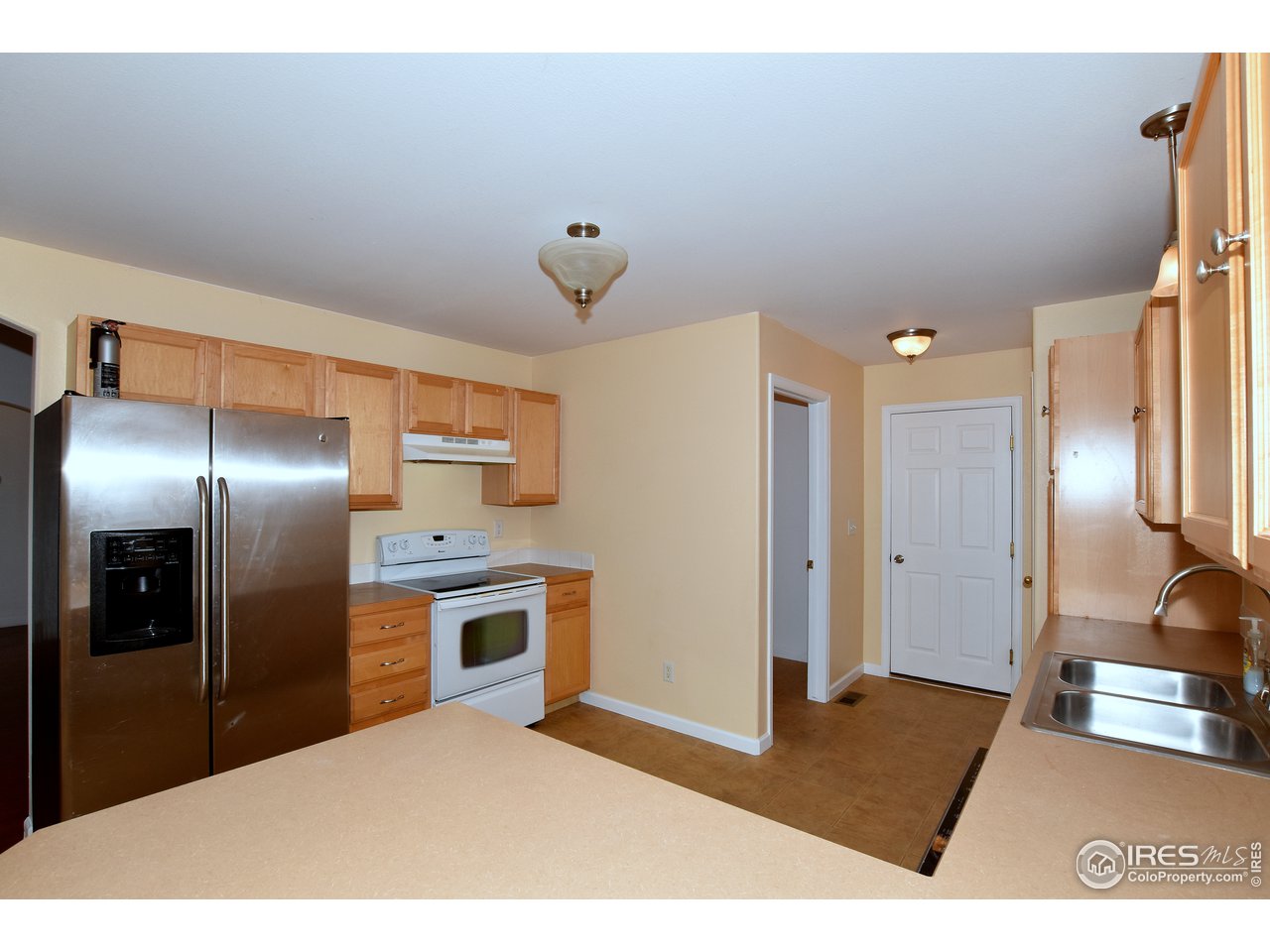924 Cliffrose Way Severance, CO 80550 - Photo 17 of 40 a kitchen with stainless steel appliances granite countertop a refrigerator and a sink
