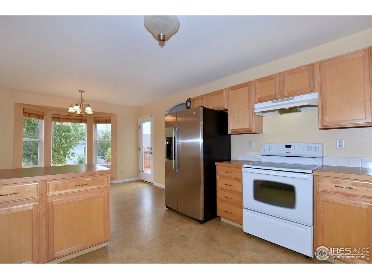 924 Cliffrose Way Severance, CO 80550 - Photo 19 of 40 a kitchen with stainless steel appliances a stove top oven and a refrigerator