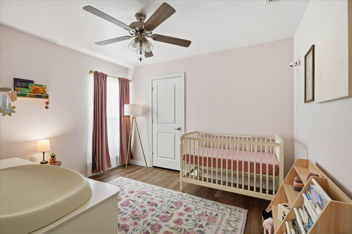13804 Paris Avenue Lubbock, TX 79423 - Photo 18 of 28 a bedroom with a bed and a chandelier