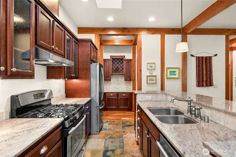 a kitchen with stainless steel appliances granite countertop a sink stove and cabinets