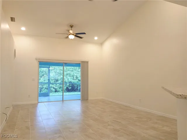 en empty room with windows and ceiling fan