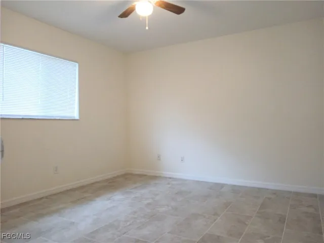 an empty room with a chandelier fan
