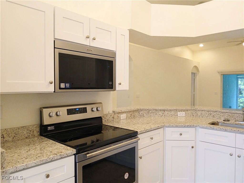 4613-4615 29th Street Southwest Lehigh Acres, FL 33973 - Photo 4 of 33 a kitchen with granite countertop a stove and a microwave