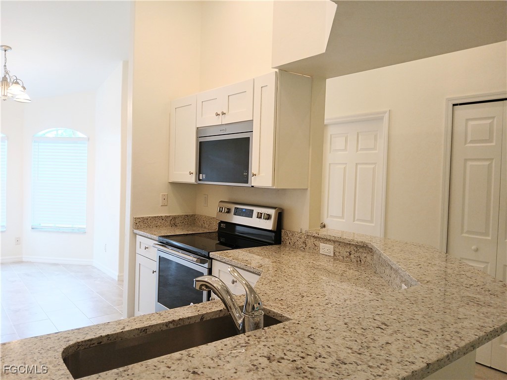 4613-4615 29th Street Southwest Lehigh Acres, FL 33973 - Photo 5 of 33 a kitchen with stainless steel appliances granite countertop a sink stove and microwave