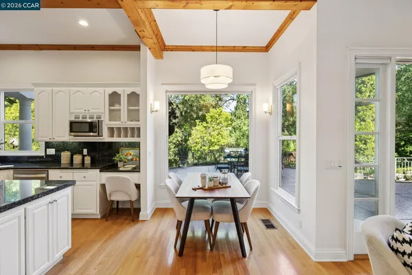 a very nice looking dining room with a large window and wooden floor