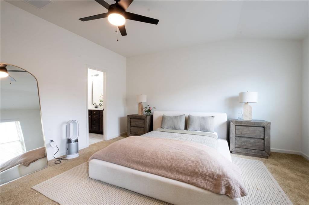 3950 Cyrus Crest Circle Northwest Kennesaw, GA 30152 - Photo 16 of 44 a spacious bedroom with a bed a couch and a chandelier