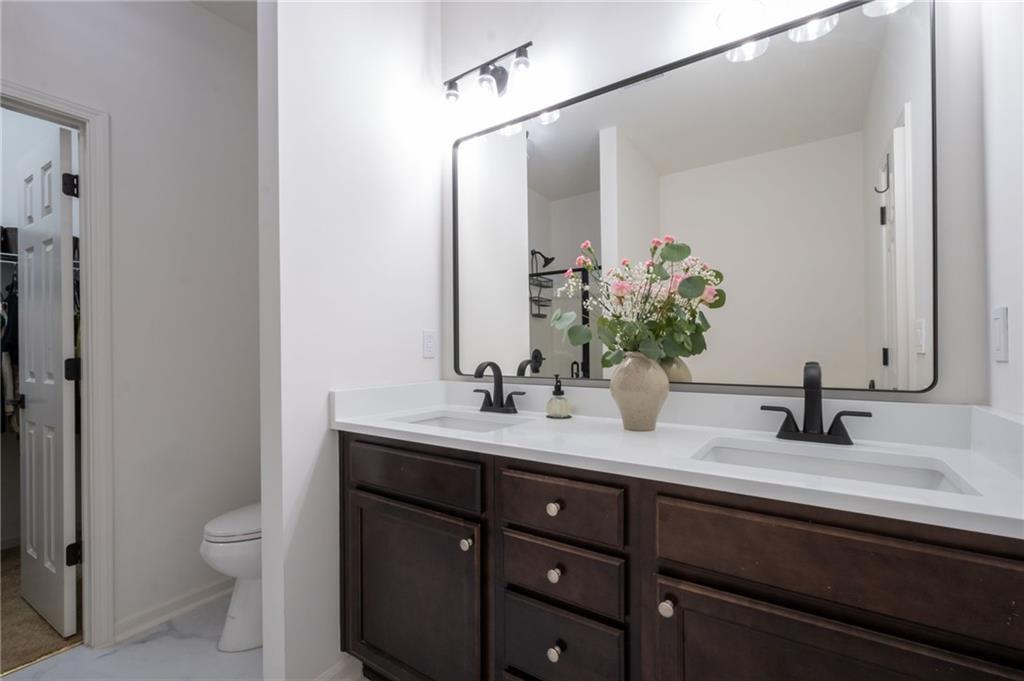 3950 Cyrus Crest Circle Northwest Kennesaw, GA 30152 - Photo 19 of 44 a bathroom with a double vanity sink toilet and a mirror