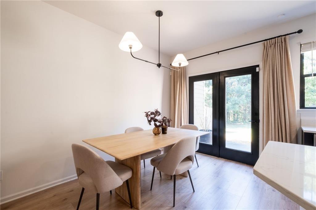 3950 Cyrus Crest Circle Northwest Kennesaw, GA 30152 - Photo 2 of 44 a dining room with wooden floor a chandelier a wooden table and chairs