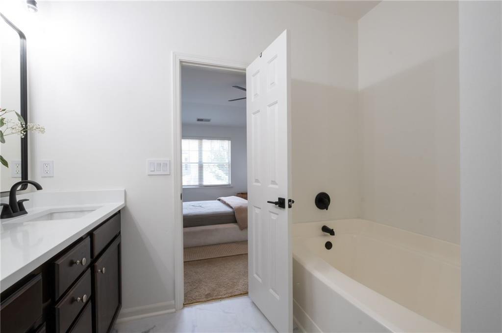 3950 Cyrus Crest Circle Northwest Kennesaw, GA 30152 - Photo 21 of 44 a bathroom with a tub sink and mirror