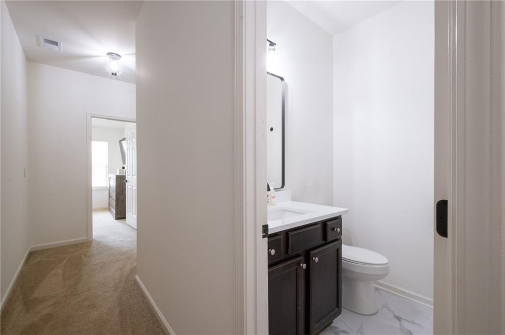 3950 Cyrus Crest Circle Northwest Kennesaw, GA 30152 - Photo 32 of 44 a bathroom with a granite countertop toilet a sink and a mirror