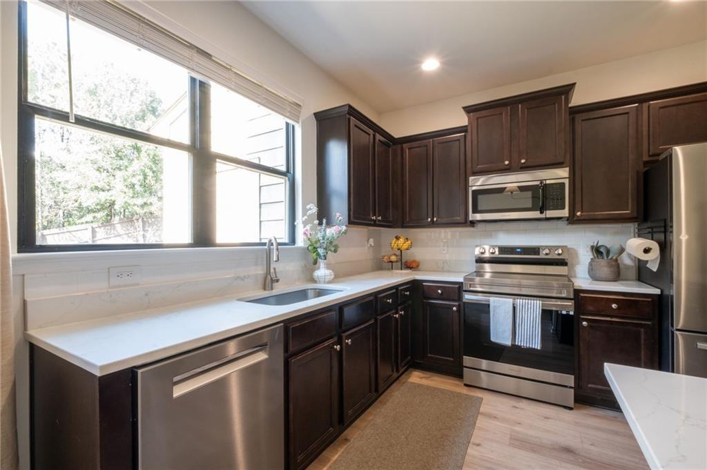 3950 Cyrus Crest Circle Northwest Kennesaw, GA 30152 - Photo 10 of 44 a kitchen with stainless steel appliances granite countertop a sink stove microwave and refrigerator