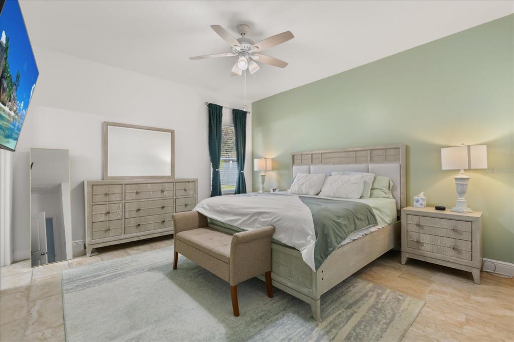 13657 Southwest 33rd Circle Ocala, FL 34473 - Photo 11 of 26 a bedroom with a bed and a chandelier