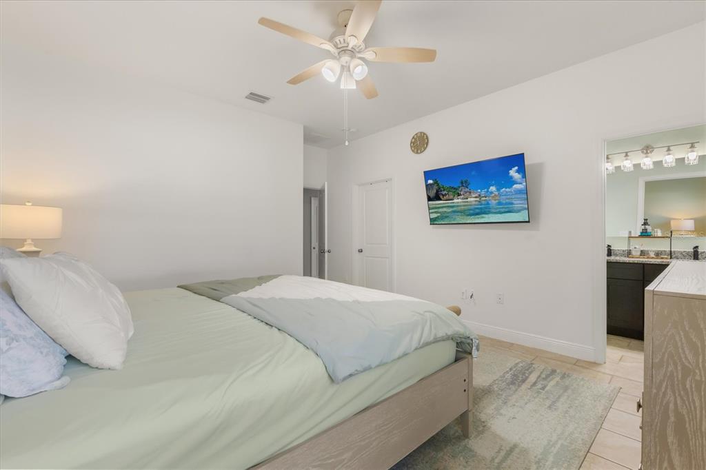 13657 Southwest 33rd Circle Ocala, FL 34473 - Photo 12 of 26 a bedroom with a bed and a painting on the wall