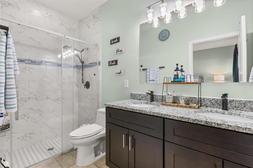 13657 Southwest 33rd Circle Ocala, FL 34473 - Photo 13 of 26 a bathroom with a granite countertop sink a toilet and shower