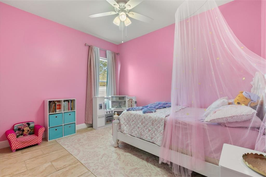 13657 Southwest 33rd Circle Ocala, FL 34473 - Photo 16 of 26 a bedroom with a bed and a chandelier