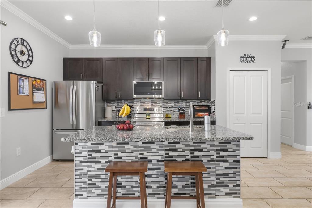 13657 Southwest 33rd Circle Ocala, FL 34473 - Photo 4 of 26 a kitchen with stainless steel appliances granite countertop a refrigerator and a stove top oven