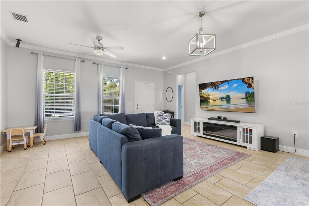 13657 Southwest 33rd Circle Ocala, FL 34473 - Photo 7 of 26 a living room with furniture a flat screen tv and a window