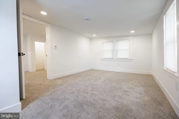an empty room with windows and closet