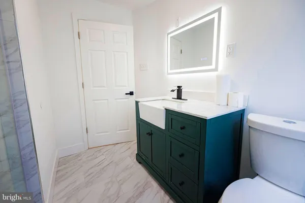 a bathroom with a toilet sink and mirror