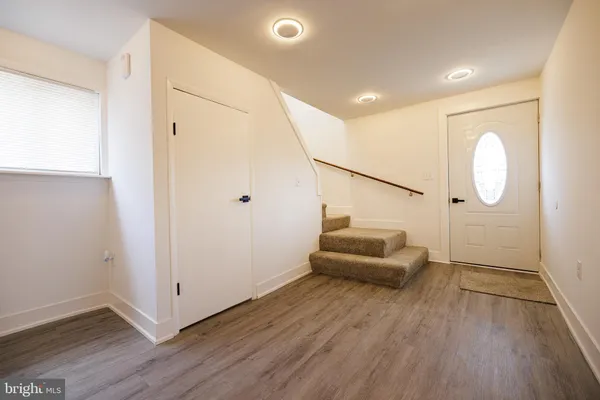 a hallway with stairs and wooden floor