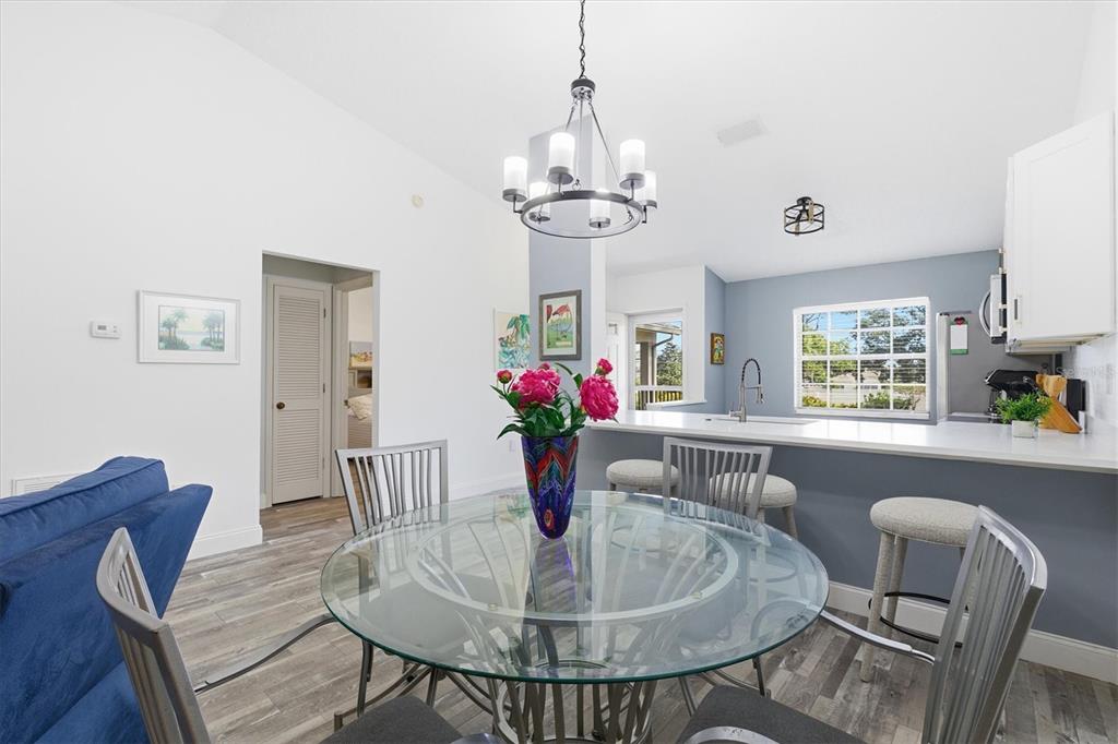 2178 Elm Street, Unit 1007 Dunedin, FL 34698 - Photo 11 of 28 a dining room with furniture a chandelier and window