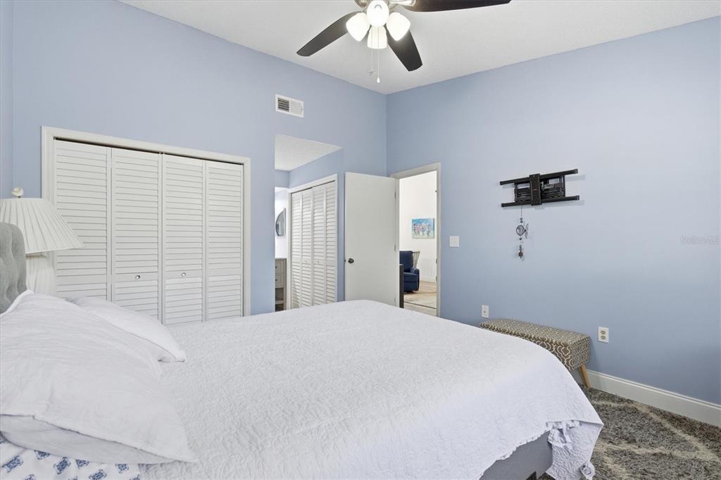 2178 Elm Street, Unit 1007 Dunedin, FL 34698 - Photo 17 of 28 a bedroom with a bed and a ceiling fan