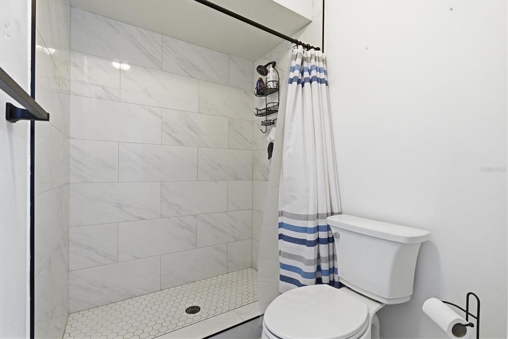 2178 Elm Street, Unit 1007 Dunedin, FL 34698 - Photo 19 of 28 a bathroom with a toilet and a shower