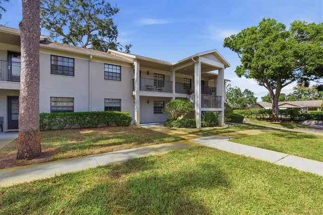 a view of a house with a yard and large tree