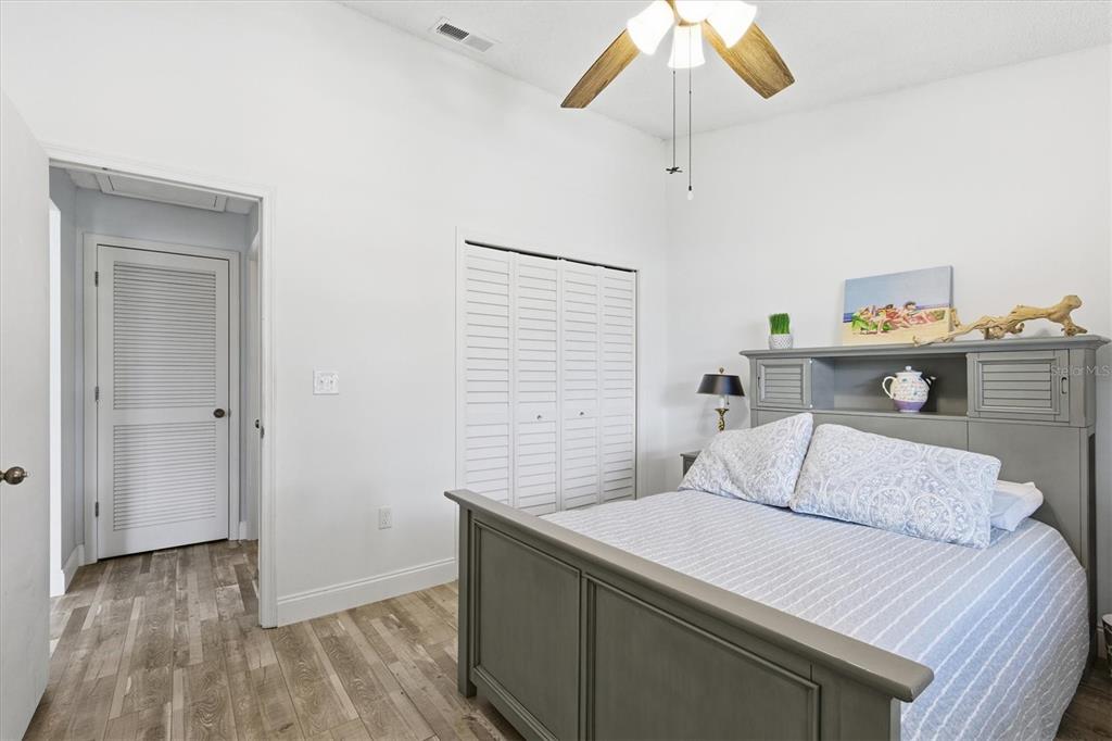 2178 Elm Street, Unit 1007 Dunedin, FL 34698 - Photo 24 of 28 a bedroom with a bed and a chandelier