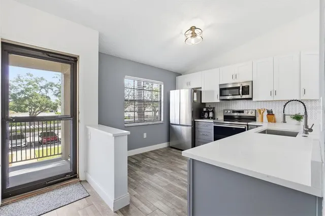 a kitchen with granite countertop a refrigerator stove top oven and sink