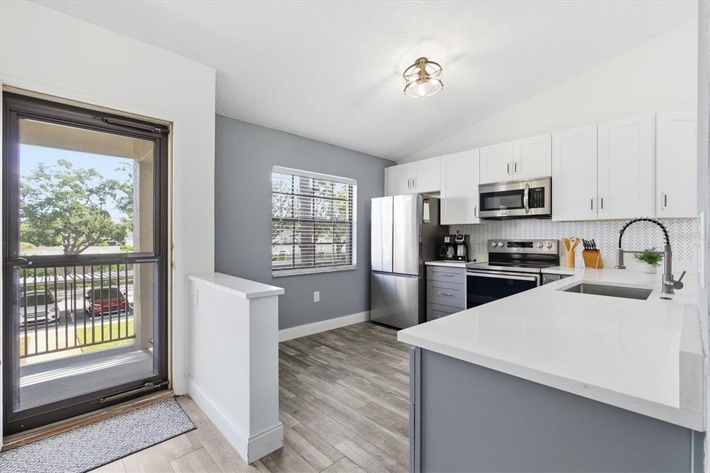 2178 Elm Street, Unit 1007 Dunedin, FL 34698 - Photo 6 of 28 a kitchen with granite countertop a refrigerator stove top oven and sink