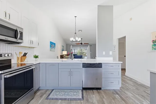 a kitchen with stainless steel appliances granite countertop a stove and a wooden floors