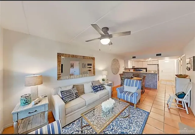 a living room with furniture and a view of kitchen