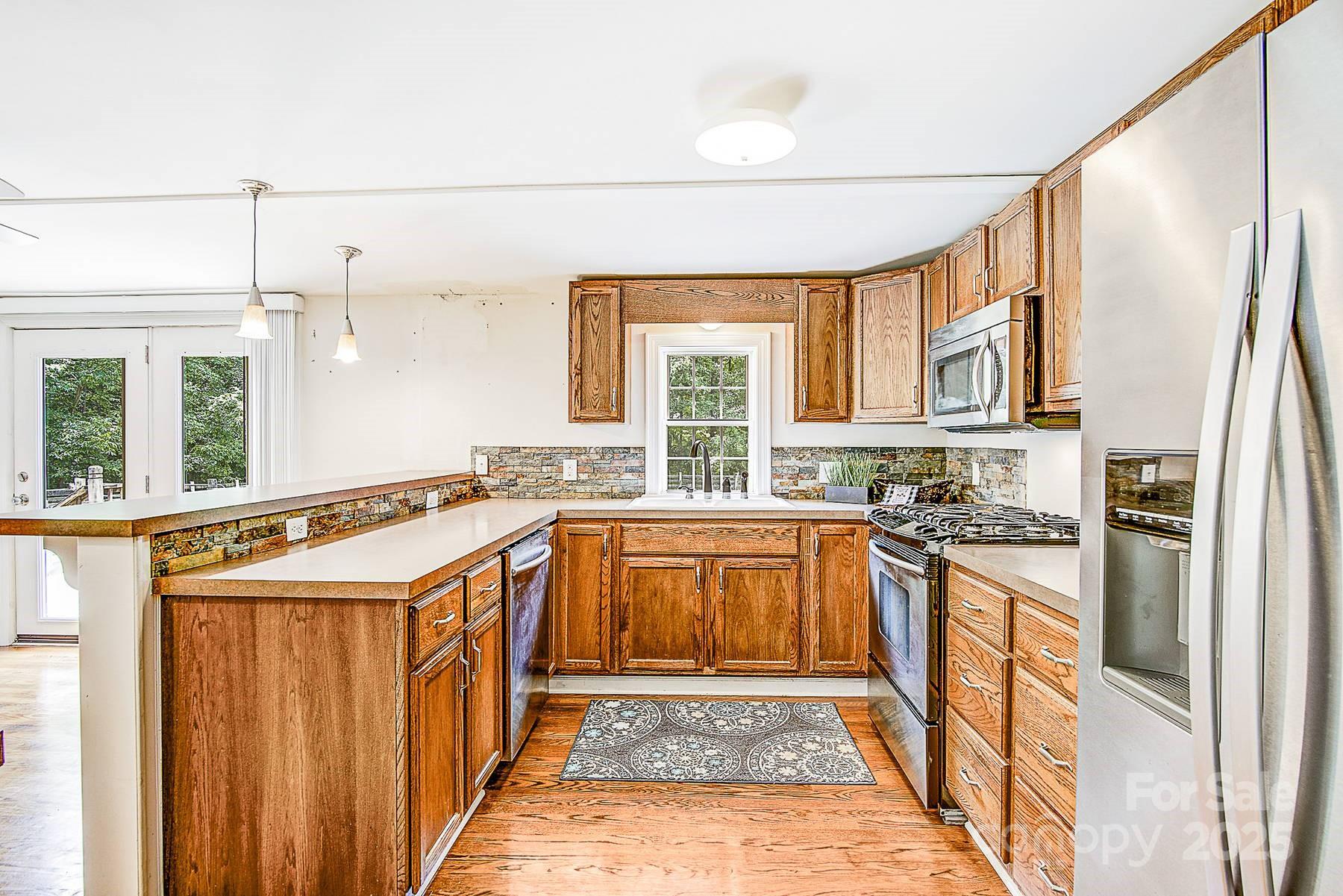 5165 Woodleaf Road Salisbury, NC 28147 - Photo 14 of 48 a kitchen with stainless steel appliances granite countertop a stove and a refrigerator