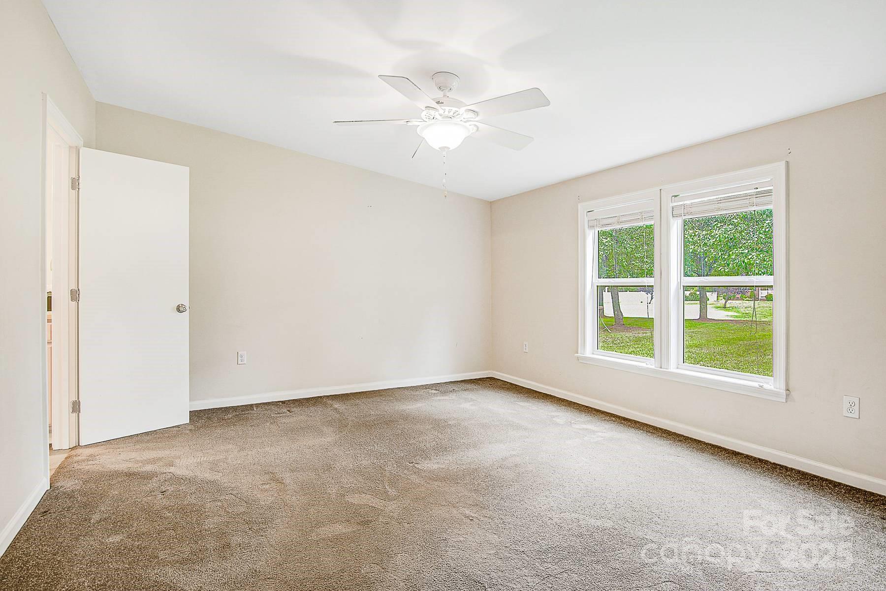 5165 Woodleaf Road Salisbury, NC 28147 - Photo 24 of 48 an empty room with a window and a ceiling fan