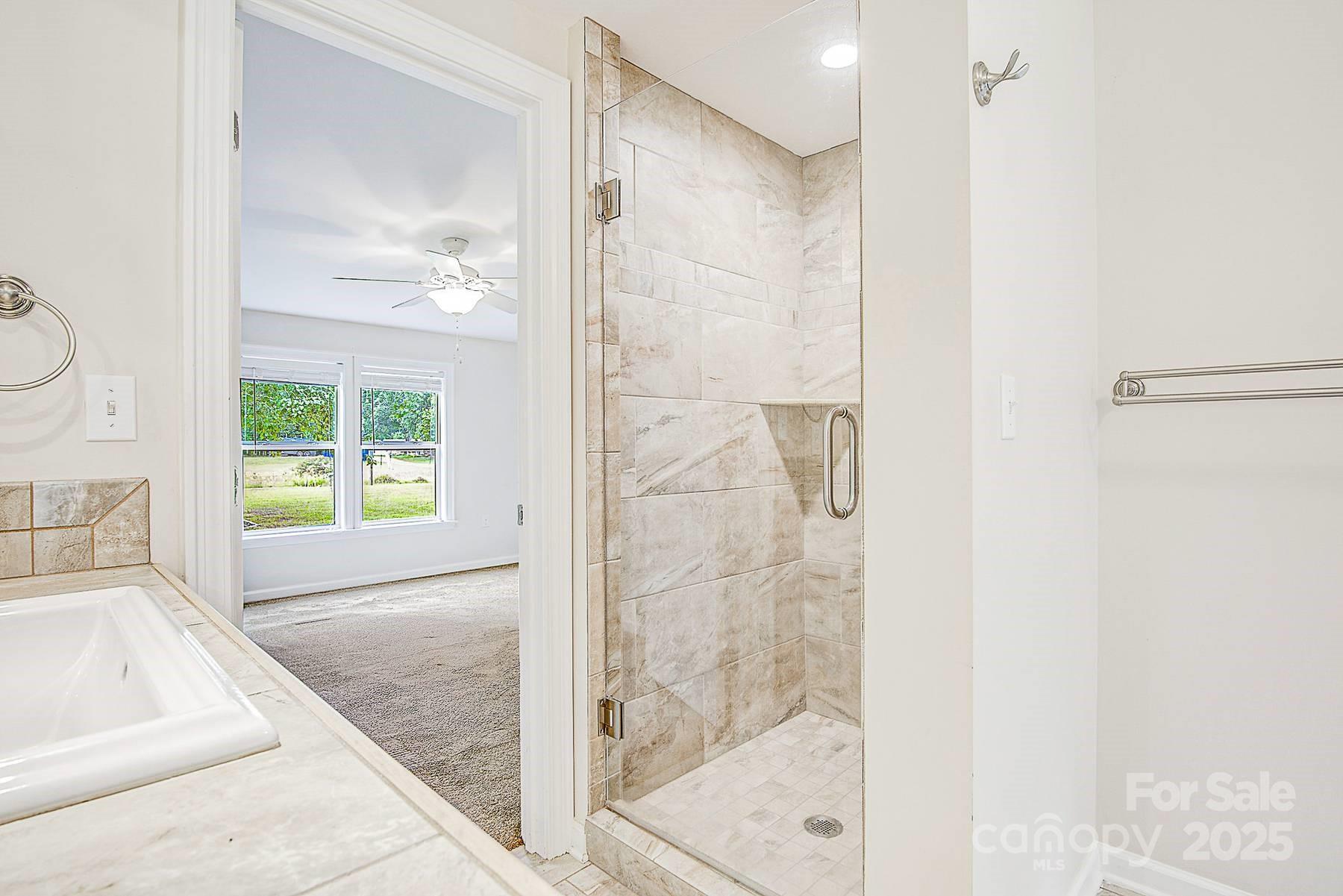 5165 Woodleaf Road Salisbury, NC 28147 - Photo 38 of 48 a bathroom with a granite countertop shower a sink and a bathtub