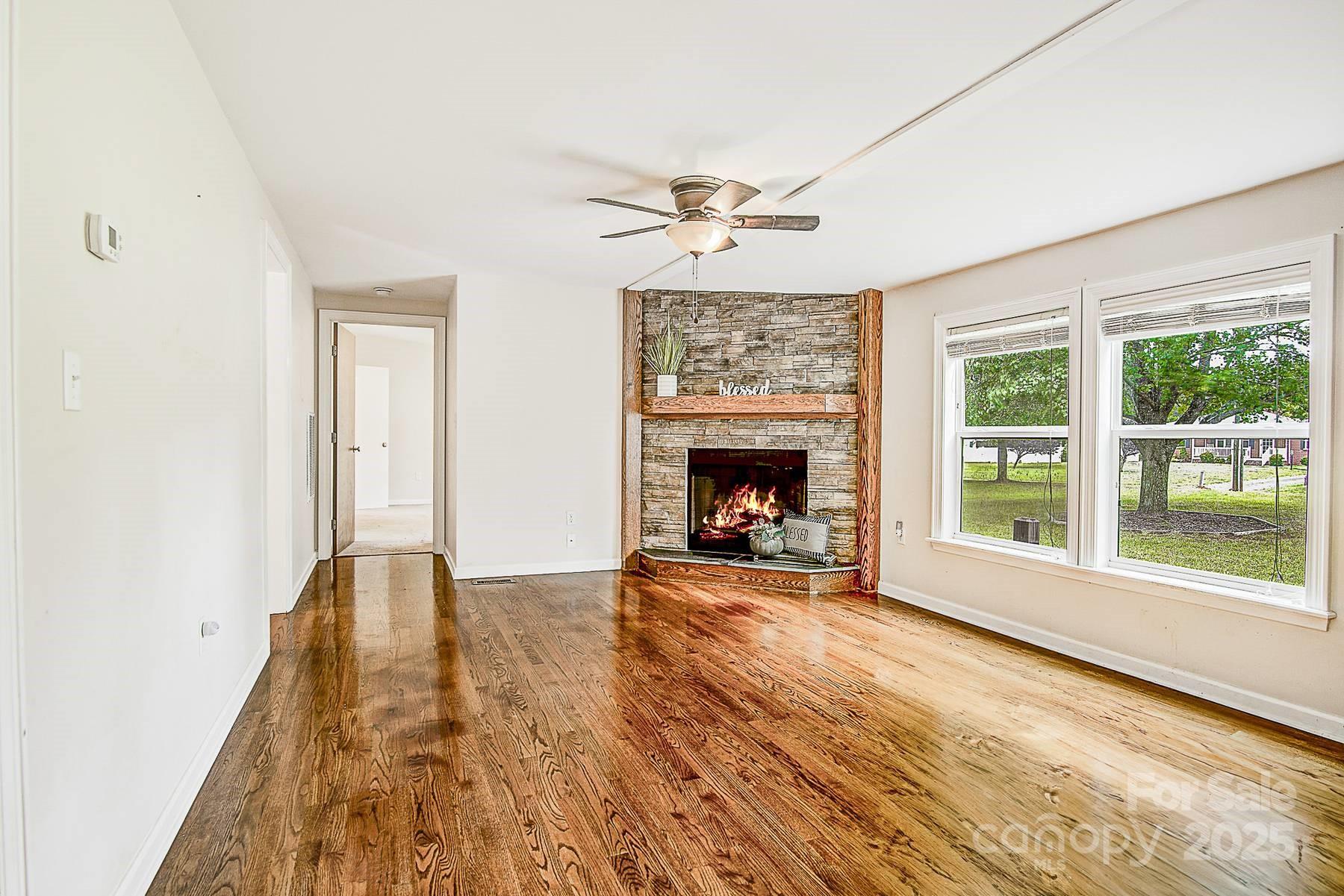 5165 Woodleaf Road Salisbury, NC 28147 - Photo 4 of 48 wooden floor fireplace and windows in an empty room