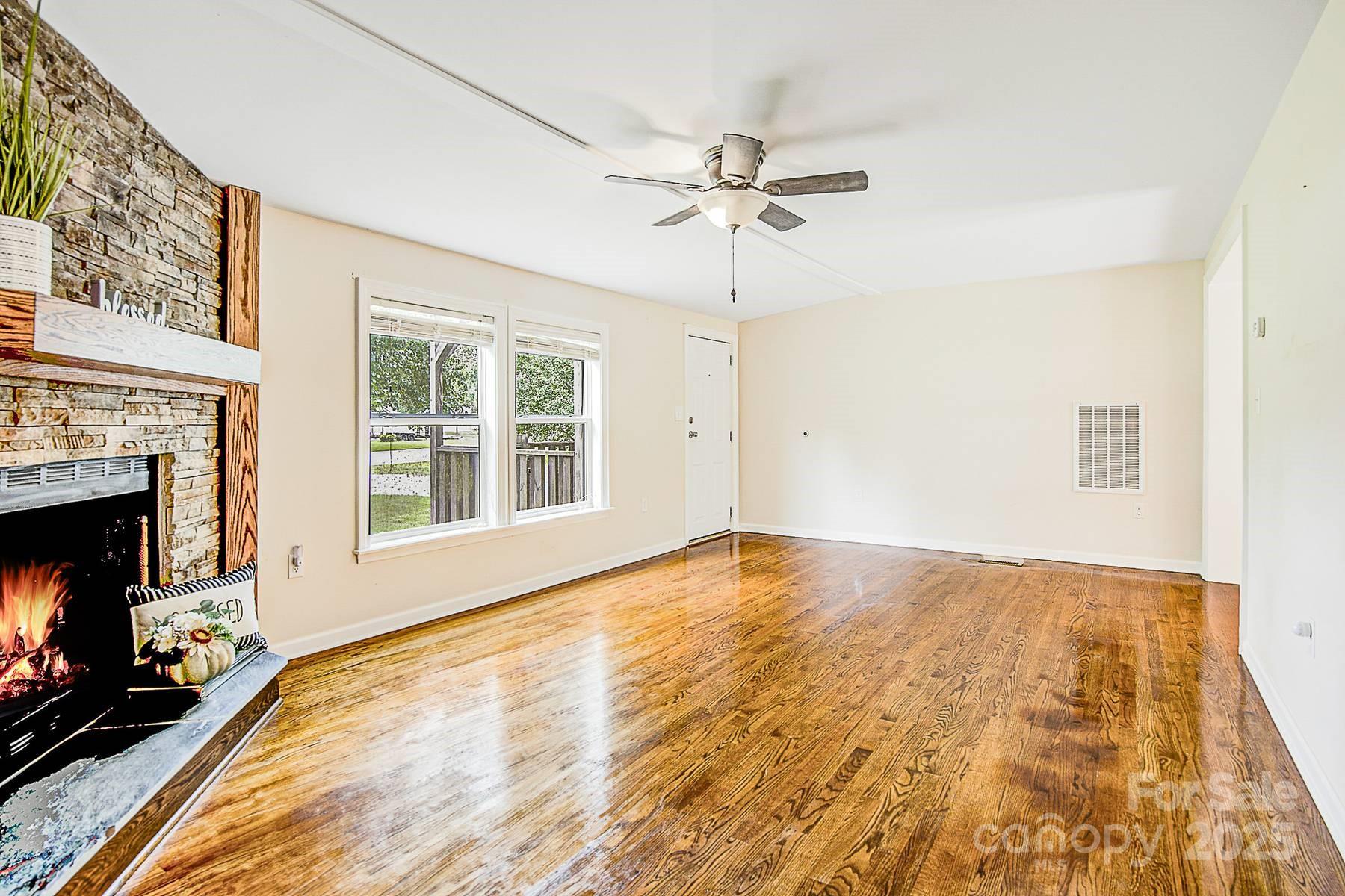 5165 Woodleaf Road Salisbury, NC 28147 - Photo 8 of 48 a view of an empty room with a fireplace and a window
