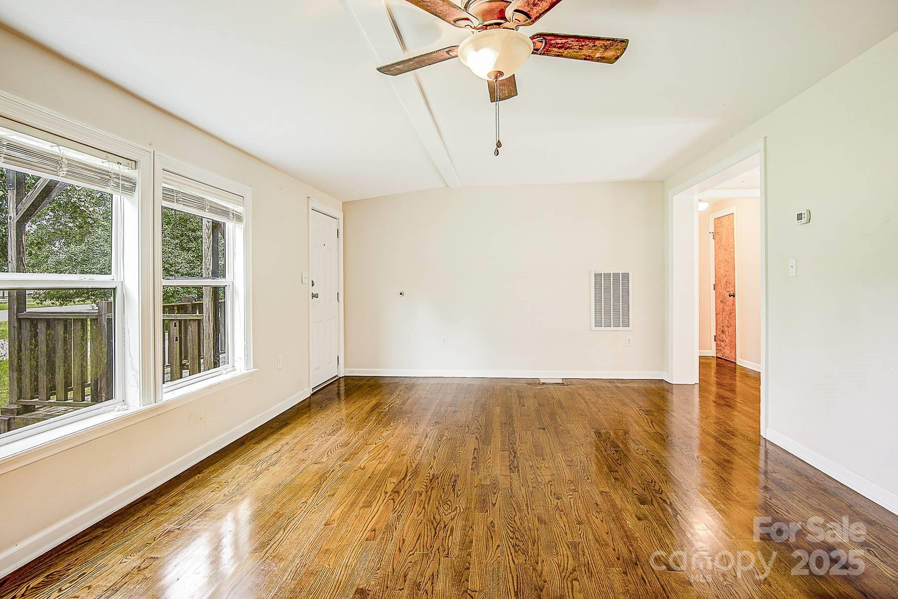 5165 Woodleaf Road Salisbury, NC 28147 - Photo 9 of 48 a view of an empty room with a window and wooden floor