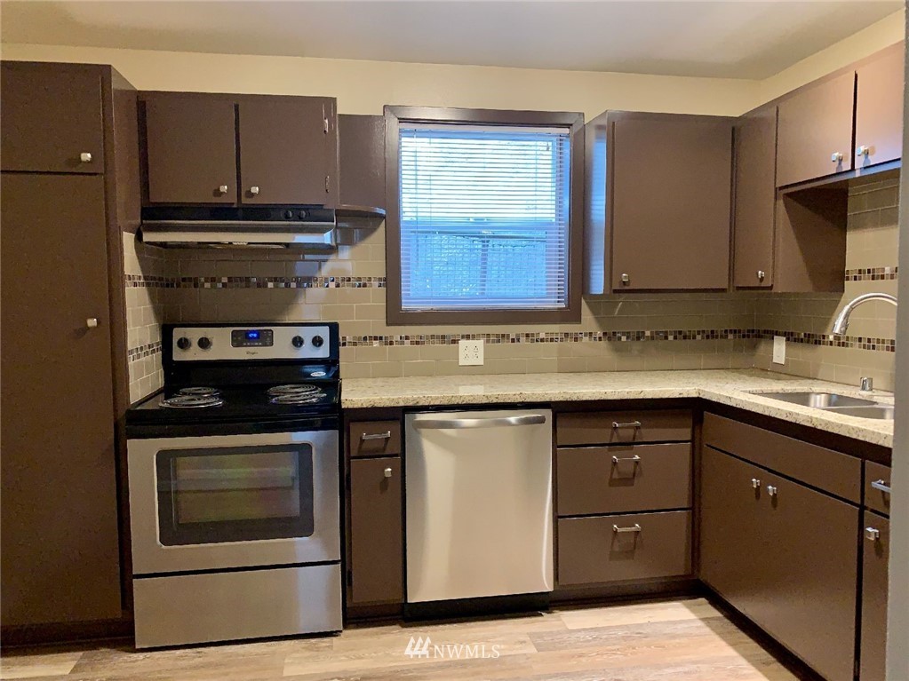 3409 Rockefeller Avenue Everett, WA 98201 - Photo 21 of 31 a kitchen with granite countertop a stove top oven sink and cabinets
